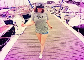 Une femme joue avec sa grosse poitrine naturelle sur le port